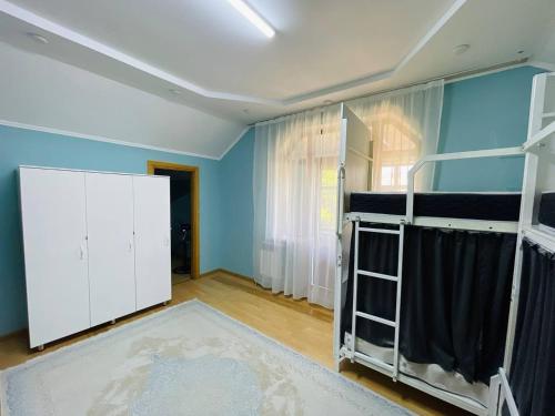 a room with blue walls and white bunk beds at Hostel Akacia in Shymkent