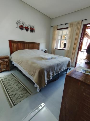a bedroom with a large bed and a window at Pouso Casa da Vovó in Tiradentes