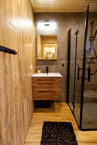 a bathroom with a sink and a shower at Letnie Chatki Nowe Guty in Nowe Guty