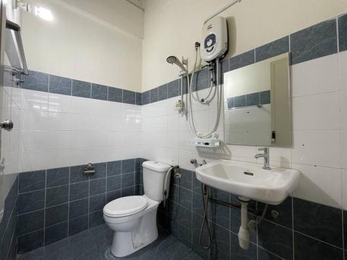 a bathroom with a shower and a toilet and a sink at Homestay Kuching BBQ and Kitchen in Kuching