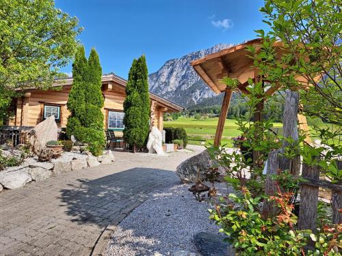 a house with a stone walkway in front of it at Almdorf im Winkl - Blockhüttendorf in Gröbming in Gröbming