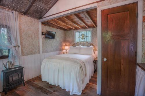 a bedroom with a bed and a wooden floor at Vintage Wild West Tiny Hotel in the Woods! in Pine City