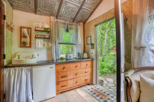 a home kitchen with a sink and a window at Vintage Wild West Tiny Hotel in the Woods! in Pine City