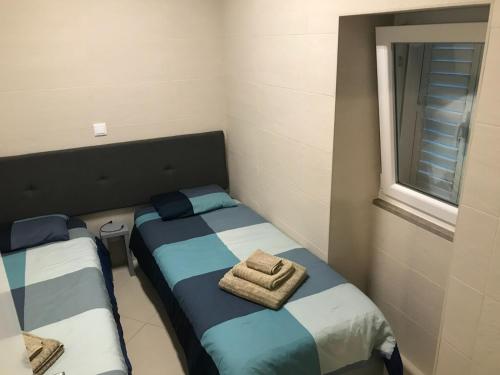 two beds in a small room with a window at Casa da Ponte de Pedra in Aljezur