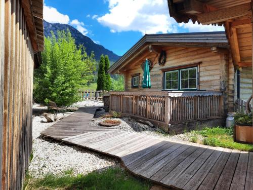 eine Holzterrasse vor einer Hütte in der Unterkunft Almdorf im Winkl - Blockhüttendorf in Gröbming in Gröbming