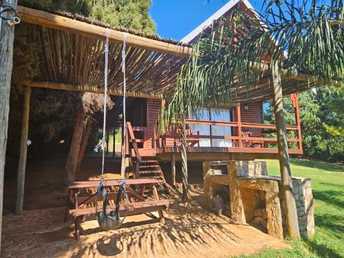 Cabaña de madera con porche y columpios en Imoflo, en Haenertsburg