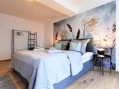 a bedroom with a large bed with a painting on the wall at BohnApartments- Haus am Markt - 1 und 2 OG - 4 Schlafzimmer - Vollausstattung - WLAN - Zentrum in Ilmenau