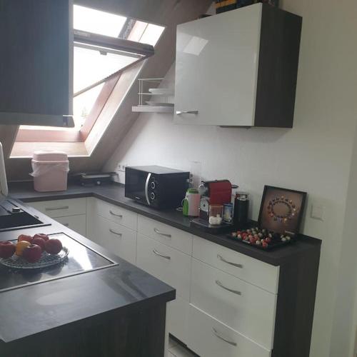 a kitchen with white cabinets and a bowl of fruit on the counter at Obere Dorfstraße in Wolfsburg