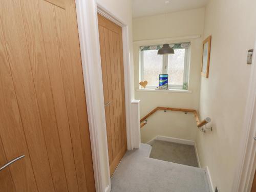 a hallway with a wooden door and a staircase at 3 Aelybryn in Llanelli