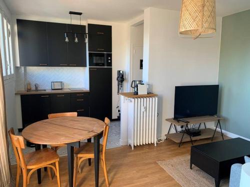 eine Küche und ein Esszimmer mit Tisch und Stühlen in der Unterkunft Le Chinchauvaud - Spacieux T2 - Coup de foudre garanti en face de la gare des Bénédictins in Limoges