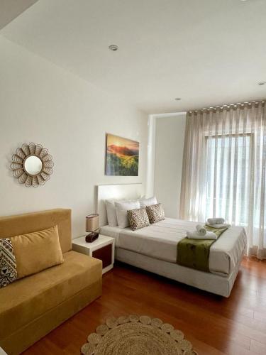 a bedroom with a large bed and a couch at CarreraHouses Canela in Vigo