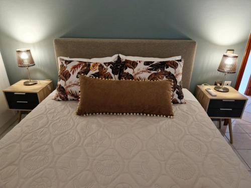 a bedroom with a bed with two nightstands and two lamps at K for Karavomilos in Karavomylos