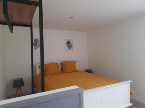 a small bedroom with a bed with orange sheets at La clef des champs gite CLOTILDE in Brouckerque