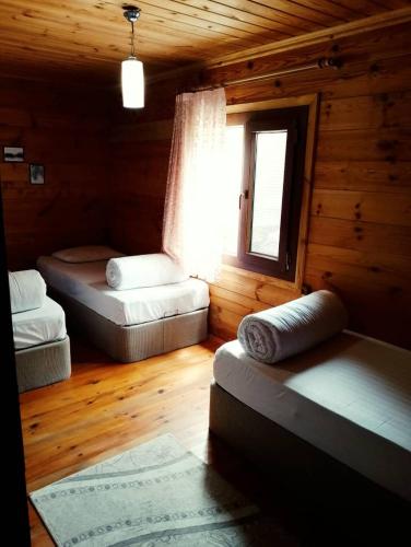 a room with three beds in a log cabin at Ayder Rainbow Gokkusagi in Ayder Yaylasi