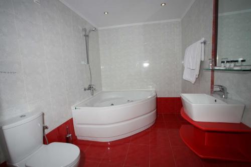a bathroom with a tub and a toilet and a sink at Princessa Riviera Resort in Pythagoreio