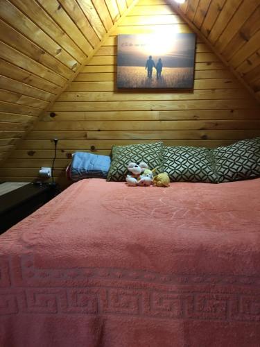 a bedroom with a bed with two stuffed animals on it at Brvnara Ruska sauna in Čajetina