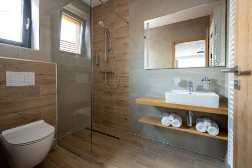 a bathroom with a toilet and a sink and a shower at Berg Liptov in Liptovský Mikuláš