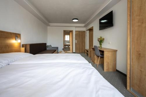 a hotel room with two beds and a desk at Berg Liptov in Liptovský Mikuláš