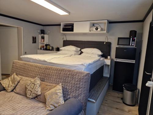 ein kleines Schlafzimmer mit einem Bett und einem Sofa in der Unterkunft GAPSAH-das Apartment mit Kino in Genhülsen