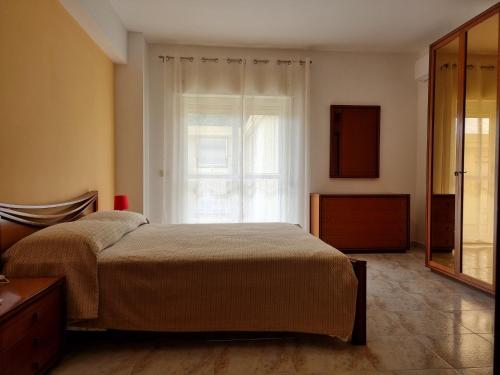 una camera con un letto e una grande finestra di casa didi' a Città di Lipari