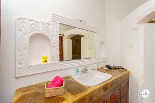 a bathroom with a sink and a mirror at Suite Two Rooms - Watamu in Watamu