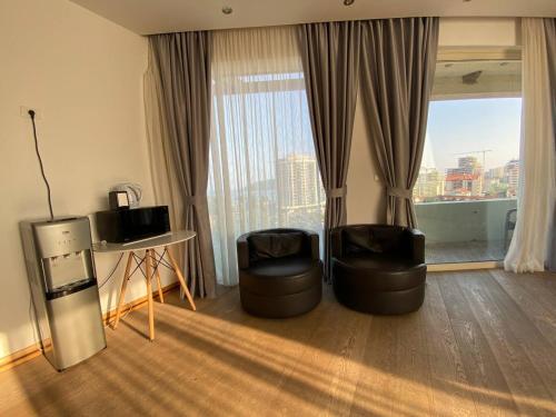 Zimmer mit 2 Stühlen, einem Tisch und einem Fenster in der Unterkunft SkyView apartments in Budva