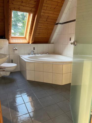 a bathroom with a bath tub and a toilet at Mueritzblick47 in Marienfelde