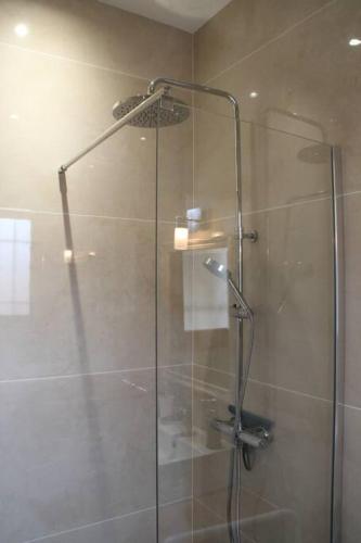 une cabine de douche avec une porte vitrée dans une salle de bain dans l'établissement Aix les Bains Appartement 2p standing 40m2 avec jardin, parking, proche thermes, à Aix-les-Bains