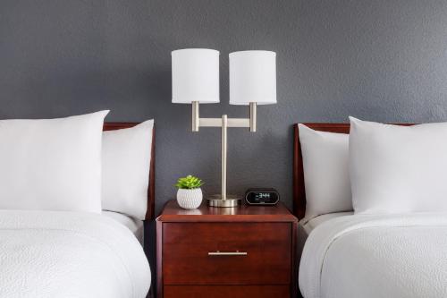 a bedroom with two beds and a night stand with a lamp at SpringHill Suites Manchester-Boston Regional Airport in Manchester