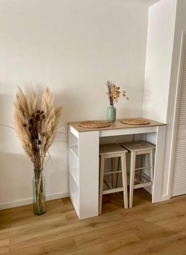 - une table blanche avec un vase de fleurs dans la chambre dans l'établissement Studio La Douce, à Vallauris