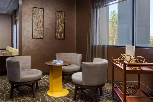 a waiting room with chairs and a table and a window at SpringHill Suites Manchester-Boston Regional Airport in Manchester