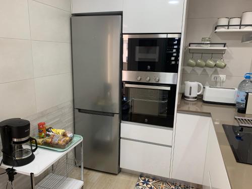 uma cozinha com um frigorífico de aço inoxidável e um micro-ondas em Coliseo Albir Beach em Albir