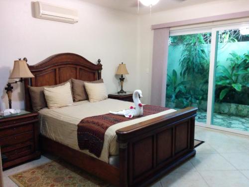 una camera da letto con un letto con un'anatra bianca sopra di Casa Beard, Spacious Guest House with High Speed WiFi & Pool. a Playa del Carmen