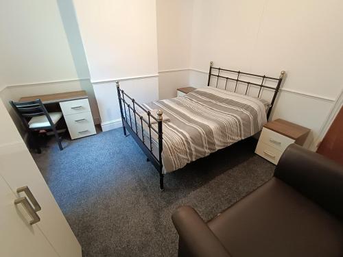 een slaapkamer met een bed, een bureau en een stoel bij Johnson Road Near Erdington Station in Birmingham