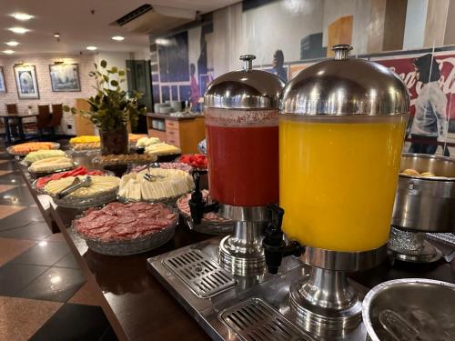 a buffet with two glasses of juice and pastries at Manhattan Plaza in Brasilia