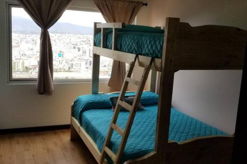 two bunk beds in a room with a window at Espectacular Casa Vacacional !Sorprendente vista! in Ambato