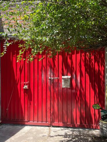 una valla roja con una puerta roja delante en Casa H236, en Ciudad de México