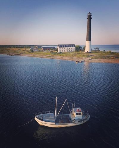 a boat in the water with a lighthouse in the background at Türju rannamaja in Türju