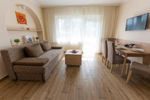 - un salon avec un canapé et une table dans l'établissement Belvárosi Nemes Apartmanház Szekszárd, à Szekszárd