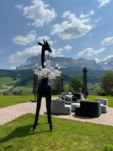a statue of a giraffe standing on a grass field at Hotel Lech Da Sompunt in Badia