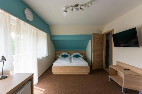 1 dormitorio con 1 cama y reloj en la pared en Belvárosi Nemes Apartmanház Szekszárd, en Szekszárd