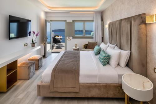 a bedroom with a large bed and a living room at Aura Suites in Firostefani
