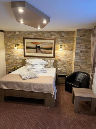 a hotel room with a bed and a chair at Apartament Darius in Moieciu de Sus