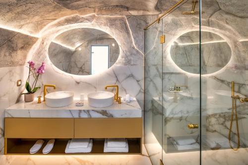 łazienka z 2 umywalkami i prysznicem w obiekcie Aura Suites w mieście Firostefani
