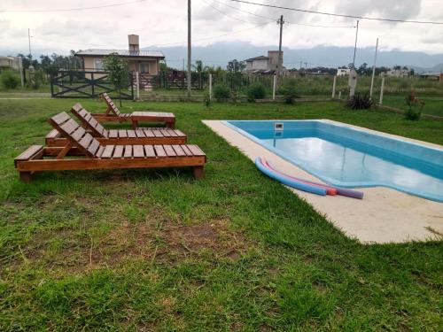 uma piscina com duas espreguiçadeiras e um insuflável em Balcon de los Andes em Salta