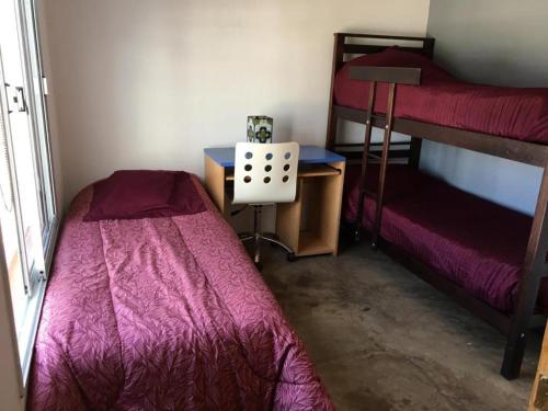 a bedroom with two bunk beds and a table and a desk at Balcon de los Andes in Salta