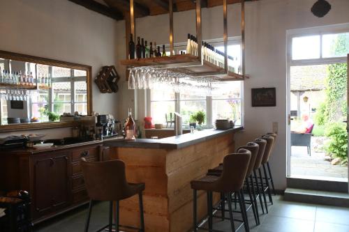 un bar con taburetes en una habitación con ventanas en WEISSES ROSS DESIGNHOTEL en Kirchheimbolanden