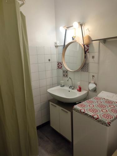 une salle de bain avec un lavabo et un miroir dans l'établissement Studio avec balcon à 7 min du port et de Garibaldi, à Nice