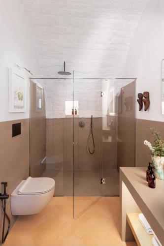 a bathroom with a toilet and a glass shower at Masseria Auraterrae in Polignano a Mare