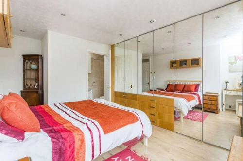 Roffey的住宿－Spacious 5 Bedroom 11 Guest Family House in Horsham，一间卧室设有两张床和大镜子
